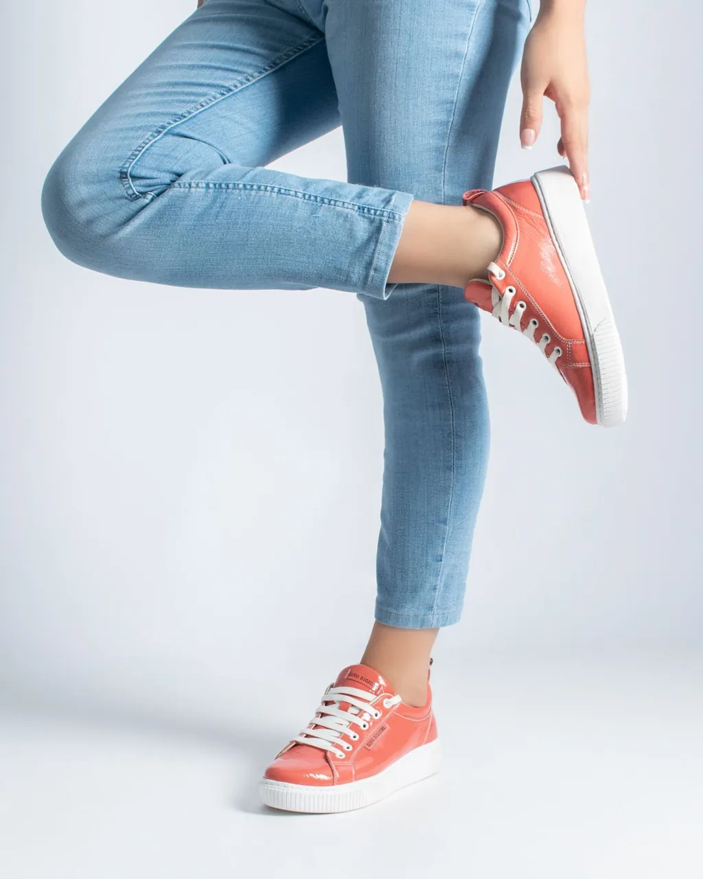 Zapatillas de cuero charol color coral con suela blanca y jean celeste — calzado para fabricantes y distribuidores que venden por mayor con su tienda mayorista B2B VentasxMayor